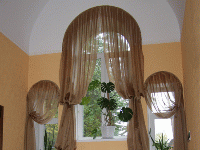 Арочное оформление  шторами с декоративными подхватами на несколько окон